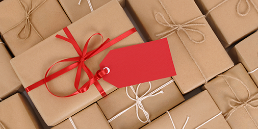Several brown paper packages, one with red ribbon and gift tag.