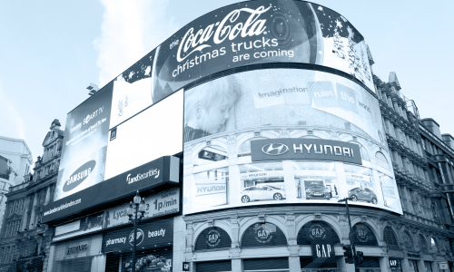 People walking below the electronic advertising display of Piccadilly Circus in London