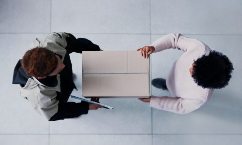 High angle shot of a young man making a delivery to a female customer