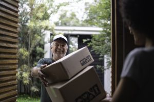 Courier delivering boxes to a young woman