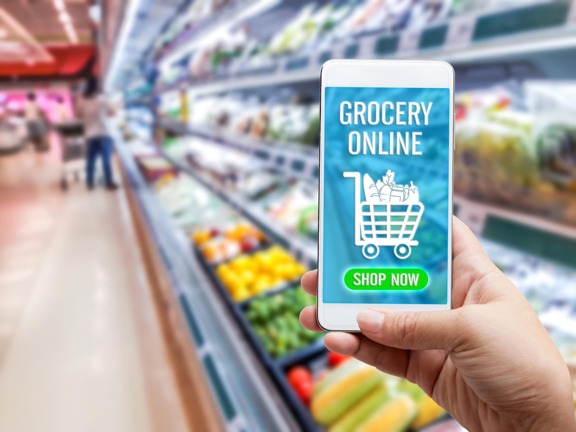 A hand with a smartphone that has online grocery app opened in the supermarket