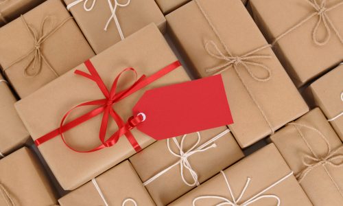 Several brown paper packages, one with red ribbon and gift tag.