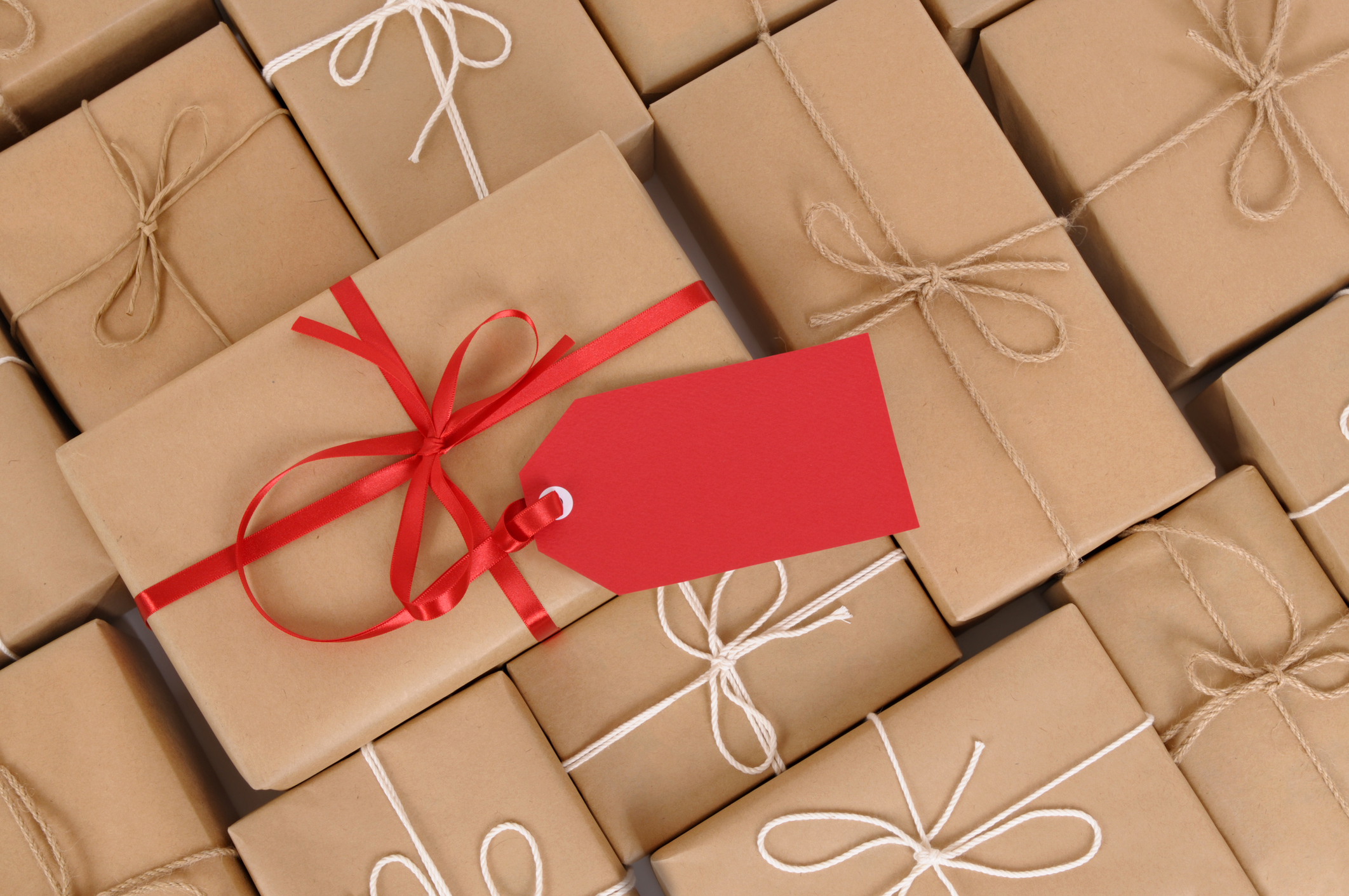 Several brown paper packages, one with red ribbon and gift tag.