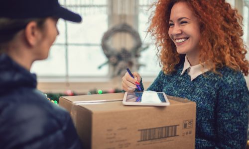 Young beautiful girl accepting a package on Christmas