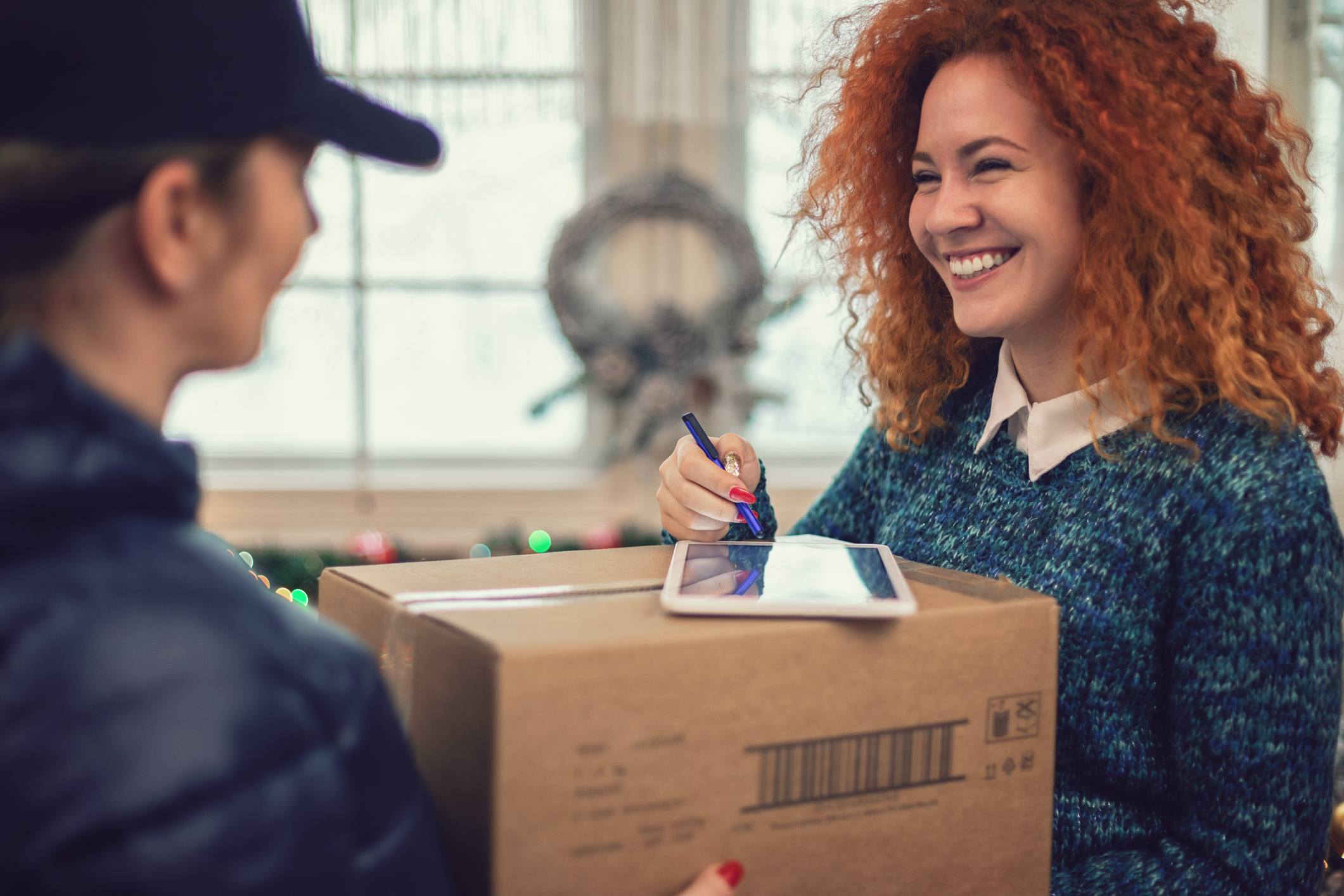 Young beautiful girl accepting a package on Christmas