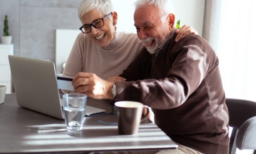 Senior people are shopping online by using laptop and credit card.