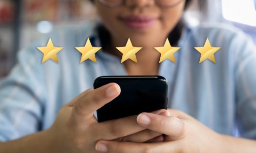 Woman using cell phone with 5 gold star customer satisfaction graphic