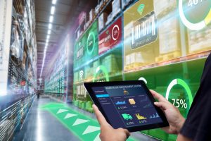 Worker hands holding tablet on blurred warehouse as background