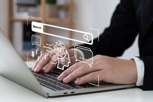 A businessman using laptop with with AI icons displayed on the screen