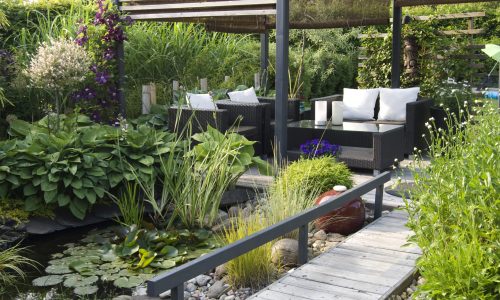 Modern patio garden lounge with a pond and outdoor sofas