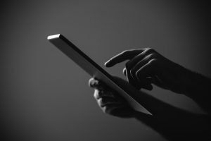 Black and White Close up shot of male hands working with Digital tablet