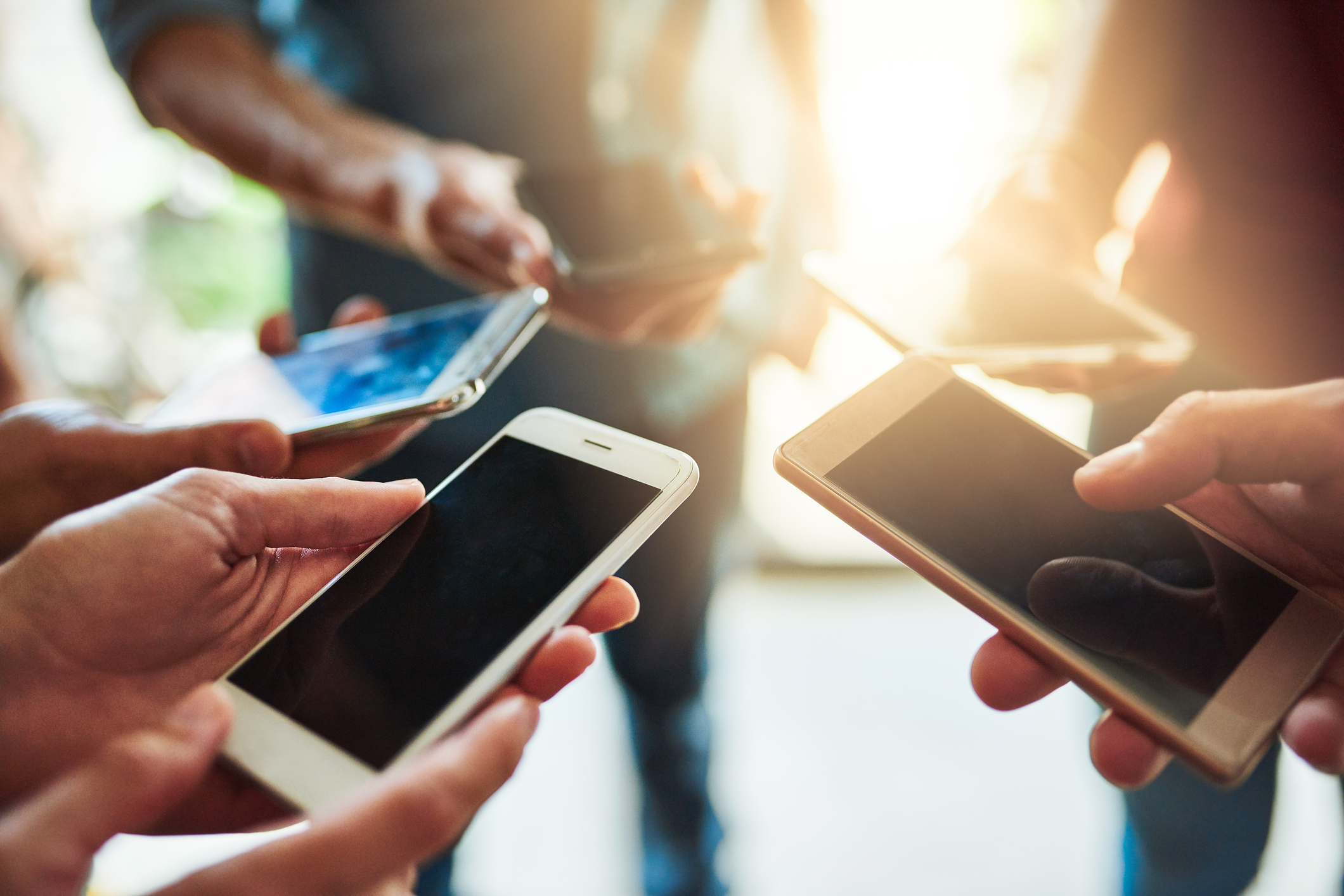 Shot of a group of colleagues using their cellphones together in an office