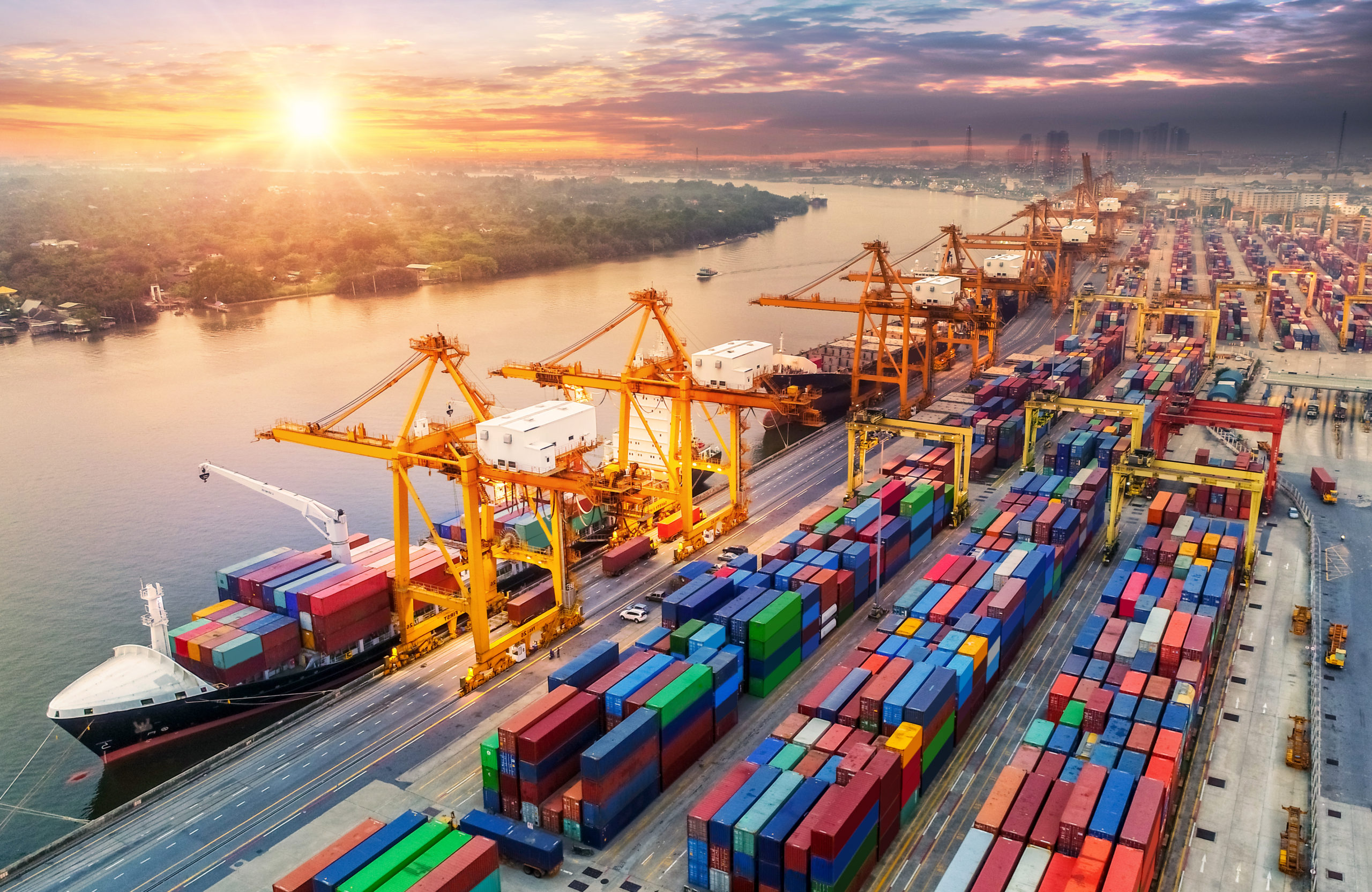 Container Cargo ships and containers in shipyard at sunrise.